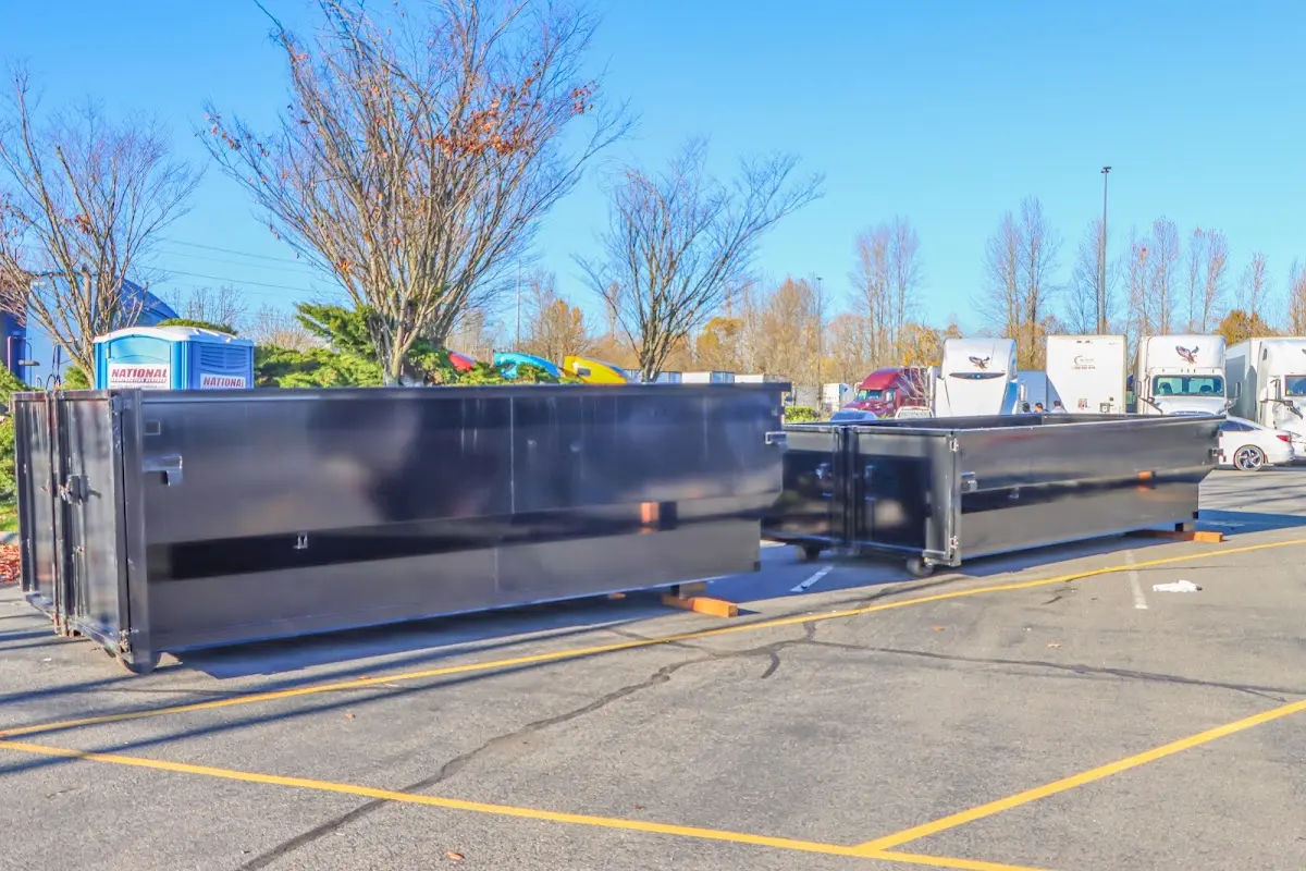 Professional dumpster rental service with roll-off container on residential driveway in Plainville